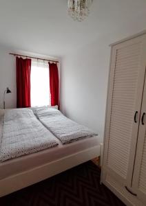 łóżko w pokoju z czerwonym oknem w obiekcie Rubin Apartment w Kielcach