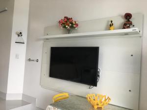 TV de pantalla plana colgada en la pared en Ap 210 Bahia Flat, Barra, en Salvador