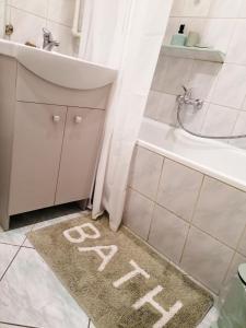 łazienka z umywalką i dywanem w łazience ze słowem modlitwa na nim w obiekcie Rubin Apartment w Kielcach
