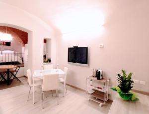 een woonkamer met een witte tafel en stoelen bij Suite al Duomo in Siena