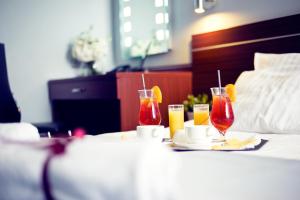 a hotel room with two drinks on a bed at Hotel Śląsk in Wrocław