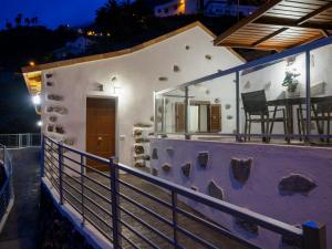 a small white house with a balcony at night at Apartamento Casa Bibiana 1 in Hermigua