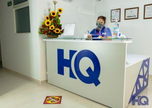 a man wearing a mask behind a counter with a sign at HOTEL QUILICHAO in Santander de Quilichao