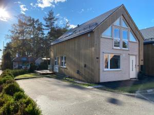 a house with a solar roof on a driveway at Årostunet 4K Nær Kristiansand dyrepark in Søgne