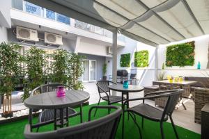 an outdoor patio with tables and chairs and plants at 9 Quartos Alojamento in Avelar
