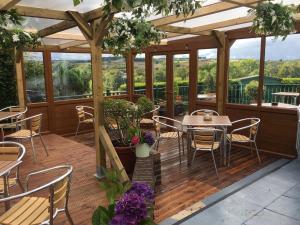 un patio con tavoli e sedie su una terrazza in legno di Beamish Park Hotel a Beamish