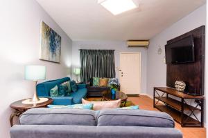 a living room with a blue couch and a tv at Hotel Tim Bamboo in Port Antonio