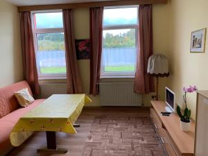 een woonkamer met een tafel en 2 ramen bij Ferienwohnung Goldener Drache in Adorf