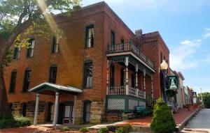 a large red brick building with a balcony at Iron Horse Hotel in Blackwater