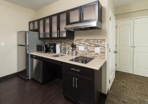 eine Küche mit einer Spüle und einem Kühlschrank in der Unterkunft Staybridge Suites - Saskatoon - University, an IHG Hotel in Saskatoon