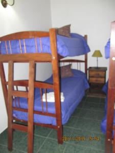 1 Schlafzimmer mit 2 Etagenbetten mit blauer Bettwäsche in der Unterkunft Apart Casas Del Centro in El Calafate