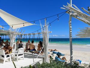 people sitting on a beach with umbrellas at Coco Tulum Beach Club Hotel in Tulum
