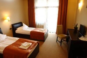 a hotel room with two beds and a desk at Hotel Transilvania Zalău in Zalău