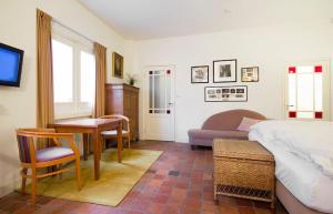 ein Schlafzimmer mit einem Bett, einem Schreibtisch und einer Couch in der Unterkunft Ground floor Jordaan Apartment in Amsterdam + 9 Fotos