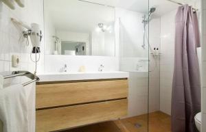 ein Badezimmer mit Waschbecken und Dusche mit Spiegel in der Unterkunft Ground floor Jordaan Apartment in Amsterdam