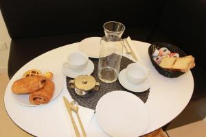 una mesa blanca con platos y tazas y un jarrón en Art Atelier Risorgimento en Roma