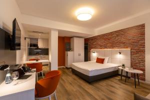 - une chambre avec un lit et un mur en briques dans l'établissement Boardinghouse Hirsch - Apartments in Kork, à Kehl
