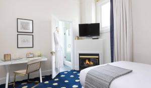 a hotel room with a bed and a fireplace at The White House Napa Valley in Napa