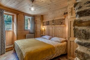 - une chambre dans une cabane en rondins avec un lit dans l'établissement Colettine, à Tignes