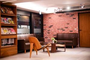 a lobby with chairs and a brick wall at Kiwi Express Hotel - Chenggong Rd in Taichung