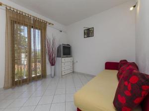 salon z kanapą i telewizorem w obiekcie Apartments Silvana - economy w mieście Supetar