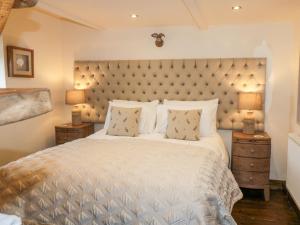 a bedroom with a large white bed with two lamps at The Cowshed in Whitby