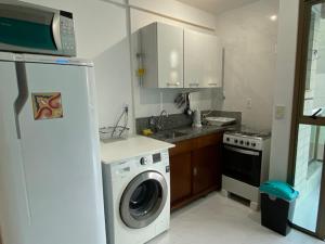 uma cozinha com uma máquina de lavar roupa e um frigorífico em Relax frente mar em Vila Velha
