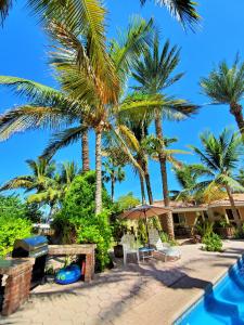 a resort with palm trees and a swimming pool at Coco Caba&ntilde;as and Casitas Vacation Rentals in Loreto