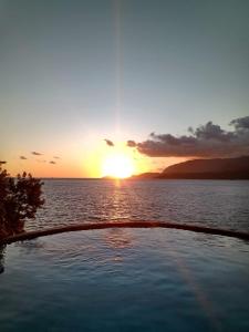 un tramonto su una cassa d'acqua con piscina di Magnífica Costeira a Ilhabela