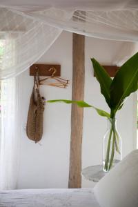 un dormitorio con una planta en un jarrón en una cama en Casas da Vila en Trancoso