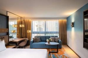 a living room with a blue couch and a table at Hyatt Regency Malta in St. Julianʼs