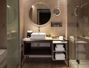 a bathroom with a sink and a mirror and a shower at Hyatt Regency Malta in St. Julianʼs