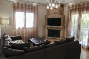 ein Wohnzimmer mit einem Sofa und einem Kamin in der Unterkunft Villa Rêve in Nea Kallikratia