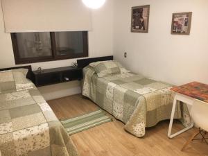 um quarto com duas camas e uma mesa e uma janela em Casa Vitacura Host em Santiago