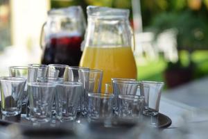 un gruppo di bicchieri seduti su un tavolo con una brocca di succo d'arancia di Hotel Boutique Casa Bella a Yautepec de Zaragoza