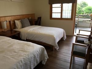 a bedroom with two beds and a window at Legendary Bed and Breakfast in Fenchihu