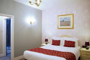 1 dormitorio con 1 cama grande con almohadas rojas en The Gordon House Hotel en Rochester