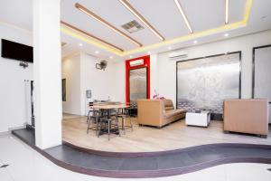 una sala de estar con una mesa y sillas en Pondok Indah Guest House by ecommerceloka, en Samarinda 22 fotos más