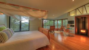 a bedroom with a bed and a living room at Lyola Pavilions in the Forest in Maleny