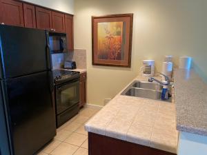 a kitchen with a black refrigerator and a sink at Ocean View Luxurious Condo-BEST location + balcony in Destin