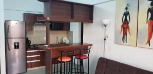 eine Küche mit einer Bar mit zwei Hockern und einem Kühlschrank in der Unterkunft Departamento Equipetrol Ejecutivo Familiar in Santa Cruz de la Sierra