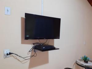 a flat screen tv hanging on a wall at Casa Chalé em Penedo in Penedo