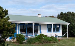 a blue and white house with a hammock at Polperro, a quintessential seaside experience in Robe
