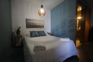 a bedroom with a white bed with a blue wall at Casa Coral in Luquillo