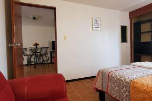 um quarto com uma cama, uma cadeira e uma mesa em El corazón de Celaya em Celaya