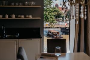 a kitchen with a view of a boat in a river at EXCLUSIVE Aparthotel MARINA in Wrocław