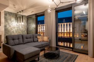 - un salon avec un canapé et une grande fenêtre dans l'établissement EXCLUSIVE Aparthotel MARINA, à Wrocław