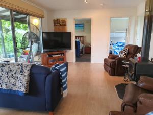 a living room with couches and a flat screen tv at Little Port Cottage in Portarlington