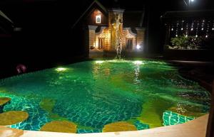 a swimming pool at night with a fountain at Chateau Orientale Resort in Luang Prabang