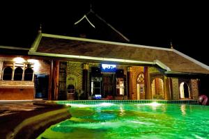 a swimming pool in front of a house at night at Chateau Orientale Resort in Luang Prabang